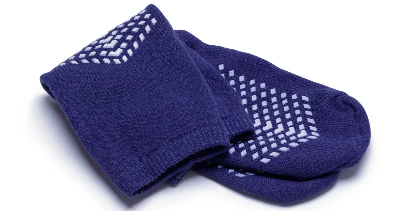 Une personne chausse des chaussettes antidérapantes avant une session de trampoline.